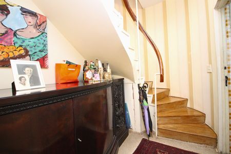 Apartamento para alugar com 108m², 2 quartos e 1 vaga Apartamento para alugar com 108m², 2 quartos e 1 vagaEscada com corrimão de madeira e pintura branca, com uma mesa de madeira e uma pintura de estilo cubista.
