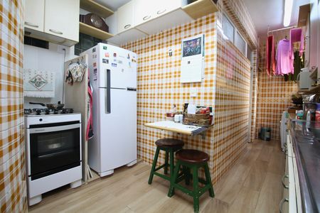 Apartamento para alugar com 108m², 2 quartos e 1 vaga Apartamento para alugar com 108m², 2 quartos e 1 vagaCozinha com geladeira, fogão e pia, com móveis brancos e azuis, e azulejos amarelos e brancos no chão e nas paredes.