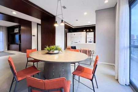 Sala de reuniões com mesa redonda e cadeiras de cor laranja, iluminação moderna e vista para a cidade. de kitnet/studio à venda com 1 quarto, 21m² em Indianópolis, São Paulo