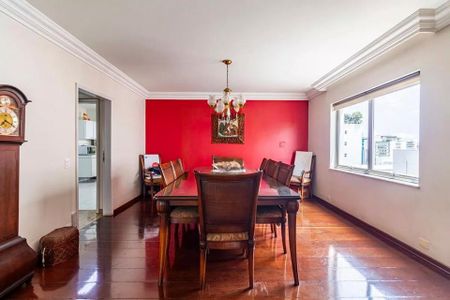 Comedor com mesa de madeira e cadeiras, com uma parede vermelha e uma janela grande. de apartamento à venda com 6 quartos, 260m² em Cerqueira César, São Paulo