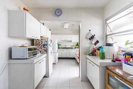 Apartamento à venda com 260m², 6 quartos e 3 vagasCozinha com geladeira, fogão, microondas e pia, com iluminação adequada e móveis brancos.