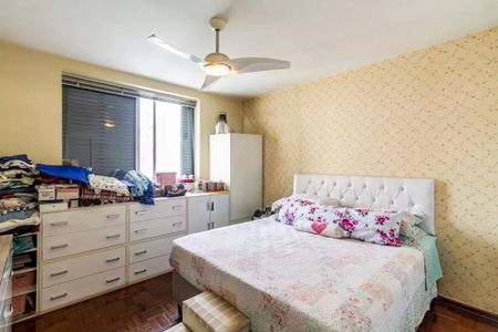 Apartamento à venda com 260m², 6 quartos e 3 vagasQuarto com cama, armários e móveis brancos, com um pouco de bagunça.