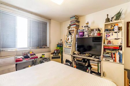 Apartamento à venda com 260m², 6 quartos e 3 vagasQuarto com cama, TV e móveis, com uma janela grande e iluminação boa.