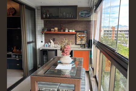 Varanda com vista para a cidade, com mesa e cadeiras de madeira, e um vaso de flores no centro da mesa. de apartamento à venda com 5 quartos, 112m² em Freguesia (Jacarepaguá), Rio de Janeiro
