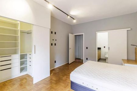 Quarto com cama, armários e piso de madeira. de casa à venda com 2 quartos, 100m² em Moema, São Paulo