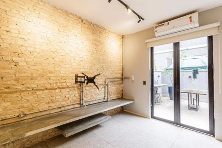 Casa à venda com 100m², 2 quartos e 1 vaga Casa à venda com 100m², 2 quartos e 1 vagaSala de estar com parede de tijolos e mesa de madeira.