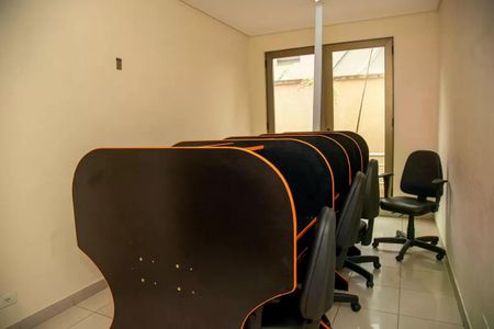 Apartamento à venda com 30m², 1 quarto e 1 vaga Apartamento à venda com 30m², 1 quarto e 1 vagaSala de jogos com mesas de computador e cadeiras, iluminada por luzes brilhantes.