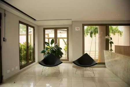 Apartamento à venda com 30m², 1 quarto e 1 vaga Apartamento à venda com 30m², 1 quarto e 1 vagaSala de espera com duas cadeiras e uma planta no centro, com janelas laterais e uma porta de vidro no fundo.