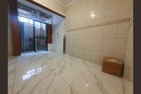 Casa à venda com 66m², 2 quartos e 1 vagaParede com tijolos brancos e um pequeno painel de azulejos no meio, com uma porta de vidro e madeira no fundo.