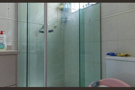 Casa à venda com 180m², 3 quartos e 2 vagasBanheiro com chuveiro e pia, com um espelho e uma prateleira acima do vaso sanitário.
