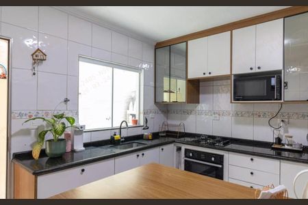 Casa à venda com 180m², 3 quartos e 2 vagasCozinha com móveis brancos e madeira, piso de porcelanato, bancada de granito, geladeira, fogão, microondas, janela grande, iluminação boa, bem decorada.