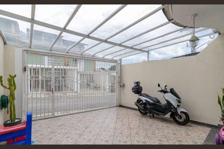 Casa à venda com 180m², 3 quartos e 2 vagasPátio com cobertura de vidro e motocicleta estacionada.