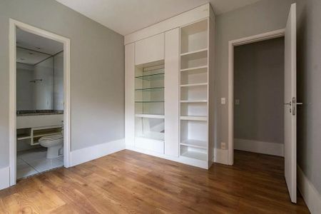 Banheiro com piso de porcelanato e vaso sanitário branco, com uma porta de vidro e uma janela pequena. de apartamento à venda com 6 quartos, 152m² em Jardins, São Paulo