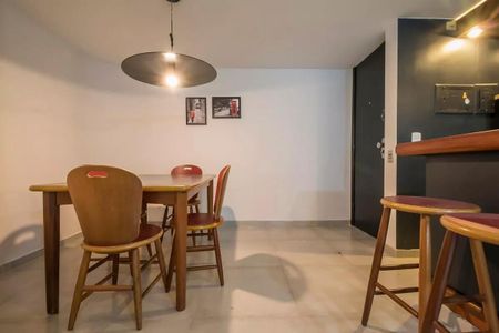 Tabela de madeira com quatro cadeiras e iluminação circular, parede branca e chão de porcelanato. de apartamento à venda com 2 quartos, 60m² em Brooklin Novo, São Paulo