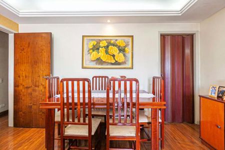 Apartamento à venda com 88m², 3 quartos e 1 vaga Apartamento à venda com 88m², 3 quartos e 1 vagaTabela de madeira com cadeiras e quadro de flores amarelas na parede.