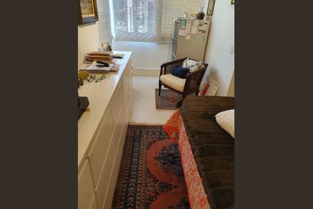 Quarto com cama, armário e mesa com objetos pessoais, com vista para a rua por uma janela com persianas fechadas. de apartamento à venda com 2 quartos, 126m² em Jardim Europa, São Paulo