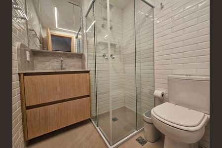 Banheiro com piso de porcelanato, pia de granito e chuveiro de vidro. de kitnet/studio à venda com 1 quarto, 24m² em Jardim Paulista, São Paulo