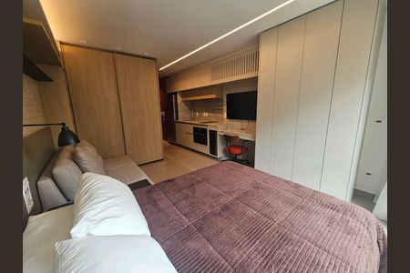 Quarto com cama, sofá e TV, com cozinha e banheiro ao fundo. de kitnet/studio à venda com 1 quarto, 24m² em Jardim Paulista, São Paulo