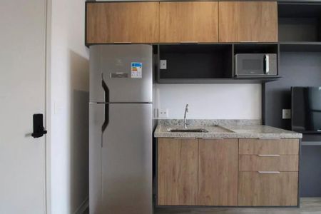 Cozinha com geladeira, fogão e microondas, com móveis de madeira e piso de porcelanato. de kitnet/studio à venda com 2 quartos, 23m² em Jardim das Acacias, São Paulo