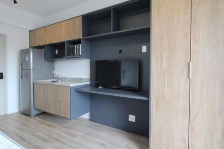 Cozinha com móveis de madeira e piso de porcelanato, com uma televisão e uma geladeira. de kitnet/studio à venda com 2 quartos, 23m² em Jardim das Acacias, São Paulo
