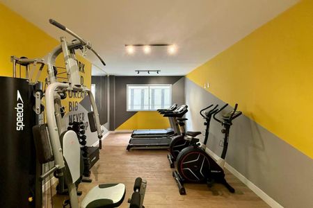 Apartamento à venda com 25m², 1 quarto e sem vaga Apartamento à venda com 25m², 1 quarto e sem vagaGinásio com equipamentos de treino e decoração amarela e cinza.