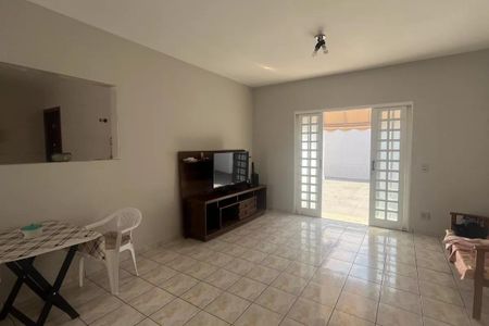 Sala com TV e porta de vidro para varanda, com piso de porcelanato e mesa de madeira. de casa à venda com 4 quartos, 168m² em Parque Taquaral, Campinas