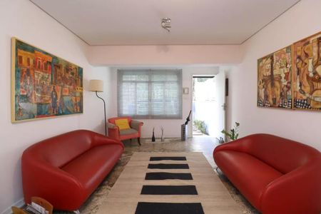 Sala com duas poltronas vermelhas e uma pintura em estilo cubista. de casa à venda com 2 quartos, 110m² em Perdizes, São Paulo