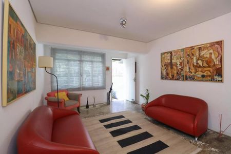 Sala de estar com móveis vermelhos e pinturas em estilo cubista. de casa à venda com 2 quartos, 110m² em Perdizes, São Paulo