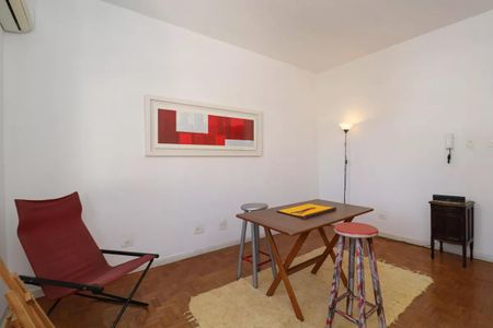 Sala com móveis simples e decoração minimalista, com uma mesa e duas cadeiras, e uma pintura em estilo moderno na parede. de casa à venda com 2 quartos, 110m² em Perdizes, São Paulo
