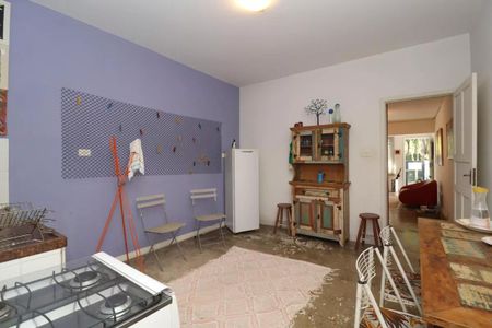 Cozinha com móveis de madeira e azulejos na parede, com um fogão e uma geladeira. de casa à venda com 2 quartos, 110m² em Perdizes, São Paulo