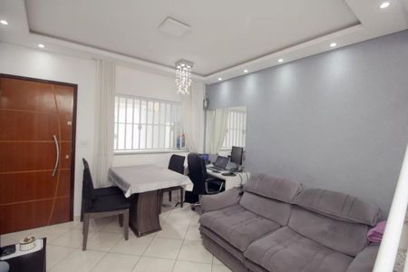 Sala com mesa e cadeiras, sofá e porta de madeira, com iluminação adequada e decoração simples. de casa à venda com 3 quartos, 100m² em Campestre, Santo André