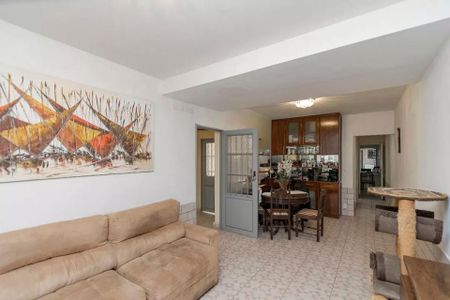 Sala com sofá, mesa e cadeiras, e quadro de arte na parede. de casa à venda com 4 quartos, 220m² em Brooklin, São Paulo