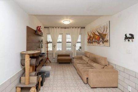 Casa à venda com 220m², 4 quartos e 3 vagas Casa à venda com 220m², 4 quartos e 3 vagasSala com sofá, quadro de arte e móveis de madeira, com iluminação natural e boa qualidade de iluminação artificial.