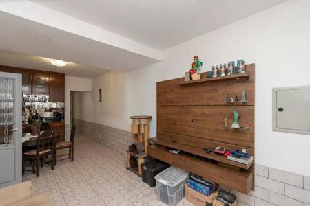 Sala com mesa de jantar, sofá e prateleira de madeira, com alguns objetos de decoração. de casa à venda com 4 quartos, 220m² em Brooklin, São Paulo