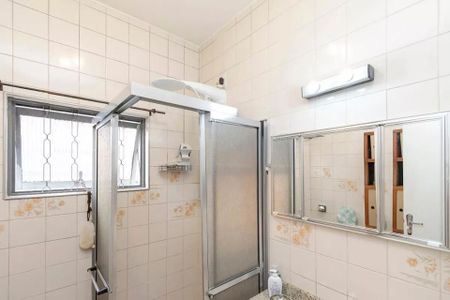Casa à venda com 220m², 4 quartos e 3 vagas Casa à venda com 220m², 4 quartos e 3 vagasBanheiro com chuveiro, pia e espelho, com teto branco e paredes de azulejos brancos e florais.