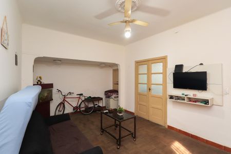 Sala com sofá, mesa e TV, com uma porta de madeira e um arco de entrada. de casa à venda com 2 quartos, 120m² em Mooca, São Paulo