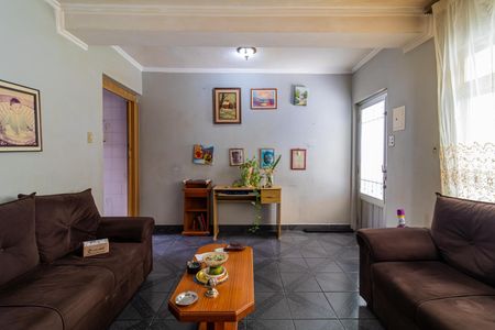 Sala de estar com móveis de madeira e pintura branca, com uma mesa de centro e uma parede com quadros e plantas. de casa à venda com 3 quartos, 100m² em Mauá, São Caetano do Sul