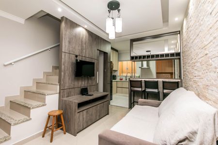 Casa à venda com 74m², 2 quartos e 1 vaga Casa à venda com 74m², 2 quartos e 1 vagaSala de estar com sofá, TV e mesa de madeira, iluminada por lâmpadas de design moderno.