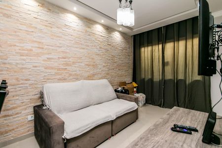 Sala de estar com sofá e TV, parede de pedra e iluminação adequada. de casa à venda com 2 quartos, 74m² em Vila Santa Edwiges, São Paulo