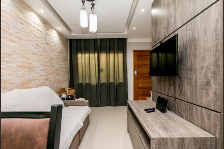 Sala com sofá, TV e mesa de madeira, parede de pedra e iluminação adequada. de casa à venda com 2 quartos, 74m² em Vila Santa Edwiges, São Paulo