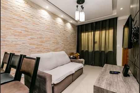 Sala de estar com sofá, mesa e TV, parede de pedra e iluminação adequada. de casa à venda com 2 quartos, 74m² em Vila Santa Edwiges, São Paulo