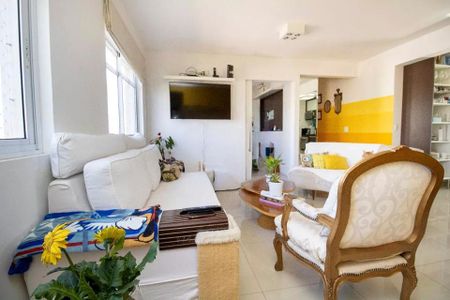 Sala de estar com sofás brancos e uma TV na parede, com uma mesa de centro e uma cadeira de madeira. de apartamento à venda com 4 quartos, 113m² em Indianópolis, São Paulo