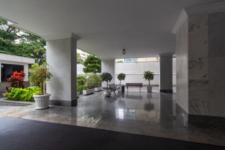 Apartamento à venda com 106m², 4 quartos e 1 vagaPátio com bancos e plantas em um edifício residencial.
