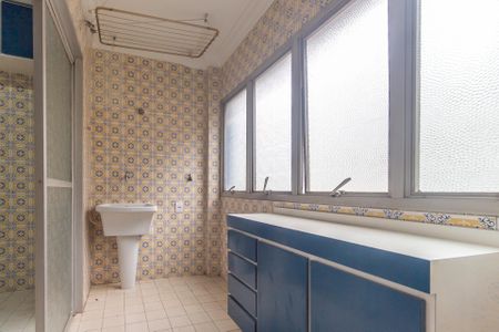 Apartamento à venda com 106m², 4 quartos e 1 vagaBanheiro com piso de azulejos amarelos e azuis, com uma pia branca e uma janela grande com vidros espelhados.
