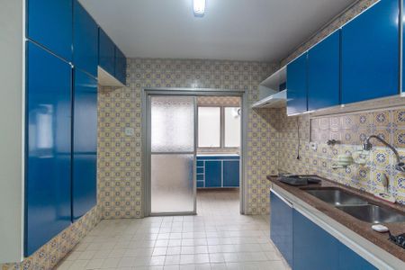 Apartamento à venda com 106m², 4 quartos e 1 vagaCozinha com móveis azuis e azulejos amarelos e azuis, com uma janela e uma porta de vidro.