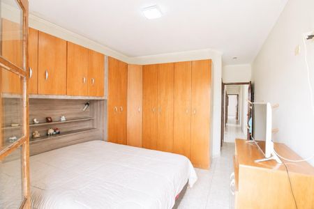 Quarto com cama, armários e prateleiras, iluminado por luz natural e com TV. de casa à venda com 4 quartos, 195m² em Jardim Ipanema(Zona Leste), São Paulo