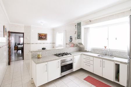 Casa à venda com 195m², 4 quartos e 4 vagas Casa à venda com 195m², 4 quartos e 4 vagasCozinha com móveis brancos, piso de porcelanato e balcão de granito.