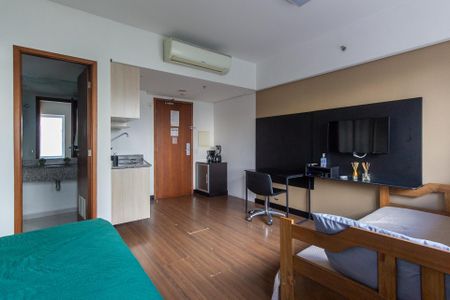 Quarto com cama, TV e mesa de trabalho, com vista para a cidade. de kitnet/studio à venda com 1 quarto, 29m² em Bela Vista, São Paulo