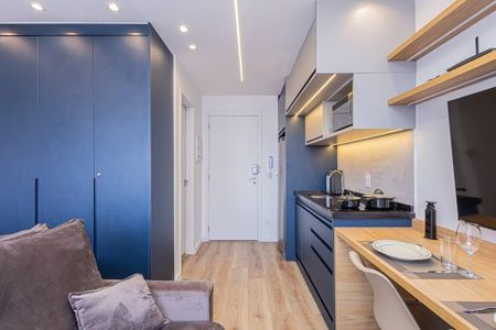 Apartamento à venda com 27m², 1 quarto e 1 vagaCozinha pequena com móveis azuis e madeira, com um sofá e uma mesa de jantar.