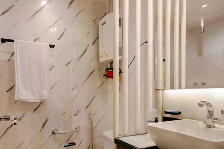 Apartamento para alugar com 110m², 2 quartos e 1 vaga Apartamento para alugar com 110m², 2 quartos e 1 vagaBanheiro com piso de porcelanato, pia e vaso sanitário brancos, e uma toalha branca pendurada no espelho.